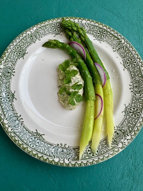 Asparagus with sauce gribiche on a green-rimmed plate