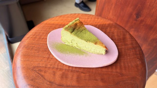 Basque-style matcha cheesecake on a rose-coloured plate
